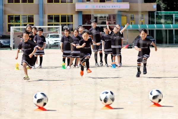 ‘FC 어린이 벤츠’ 축구교실에 참여한 창원 구산 초등학교 학생들이 전문 강사진의 지도하에 축구공을 향해 달리고 있다.