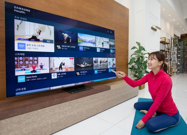 삼성전자 모델이 2020년형 삼성 스마트 TV용 '삼성 헬스' 앱으로 홈 트레이닝 영상을 시청하고 있다.