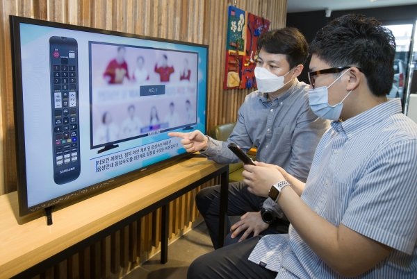 삼성전자 상품전략팀 직원이 서울 관악구에 위치한 실로암 시각장애인 복지관에서 한 시각장애인에게 삼성전자 스마트TV의 접근성 기능에 대해 설명하고 있다